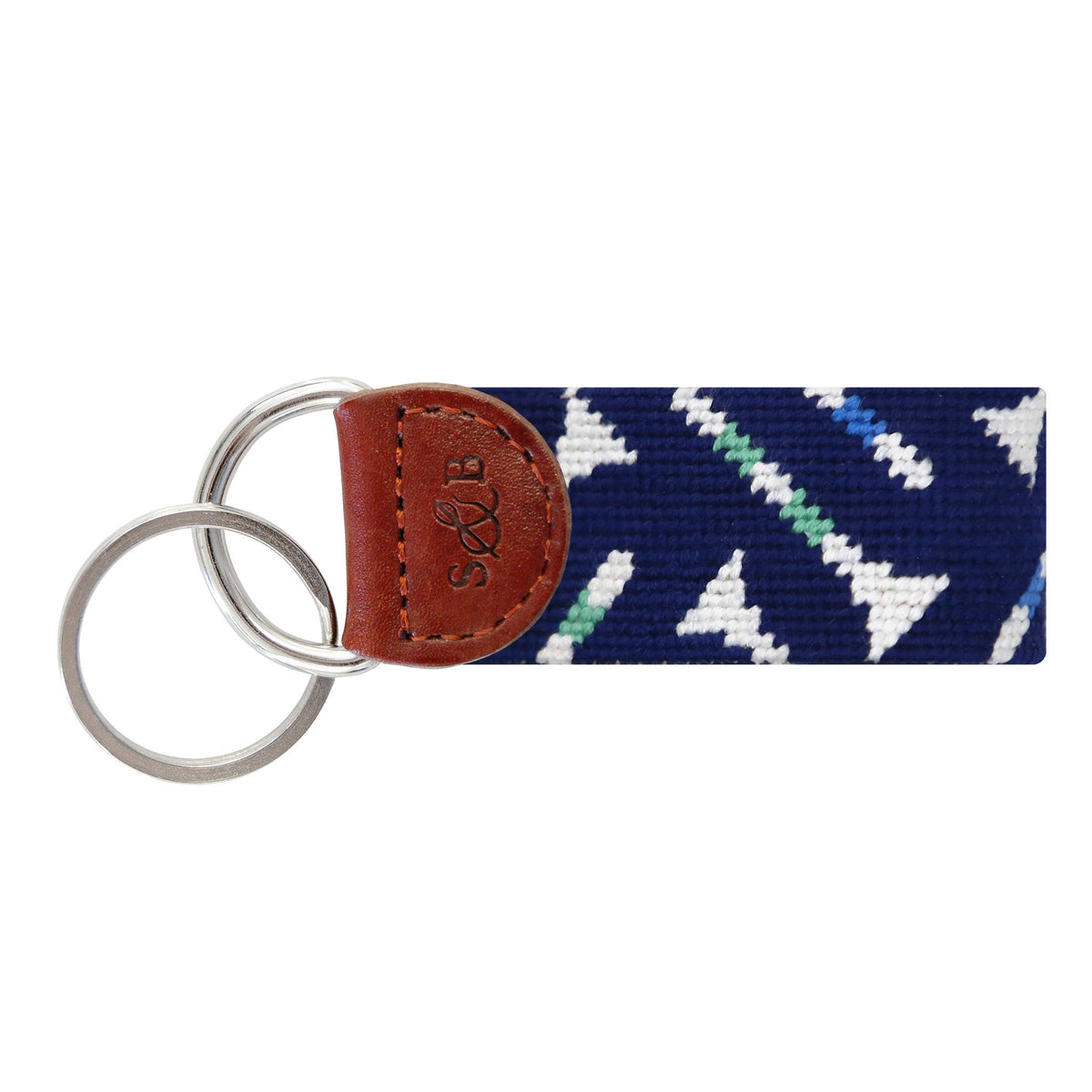 Dark navy needlepoint key fob with golf tee pattern and brown leather tab