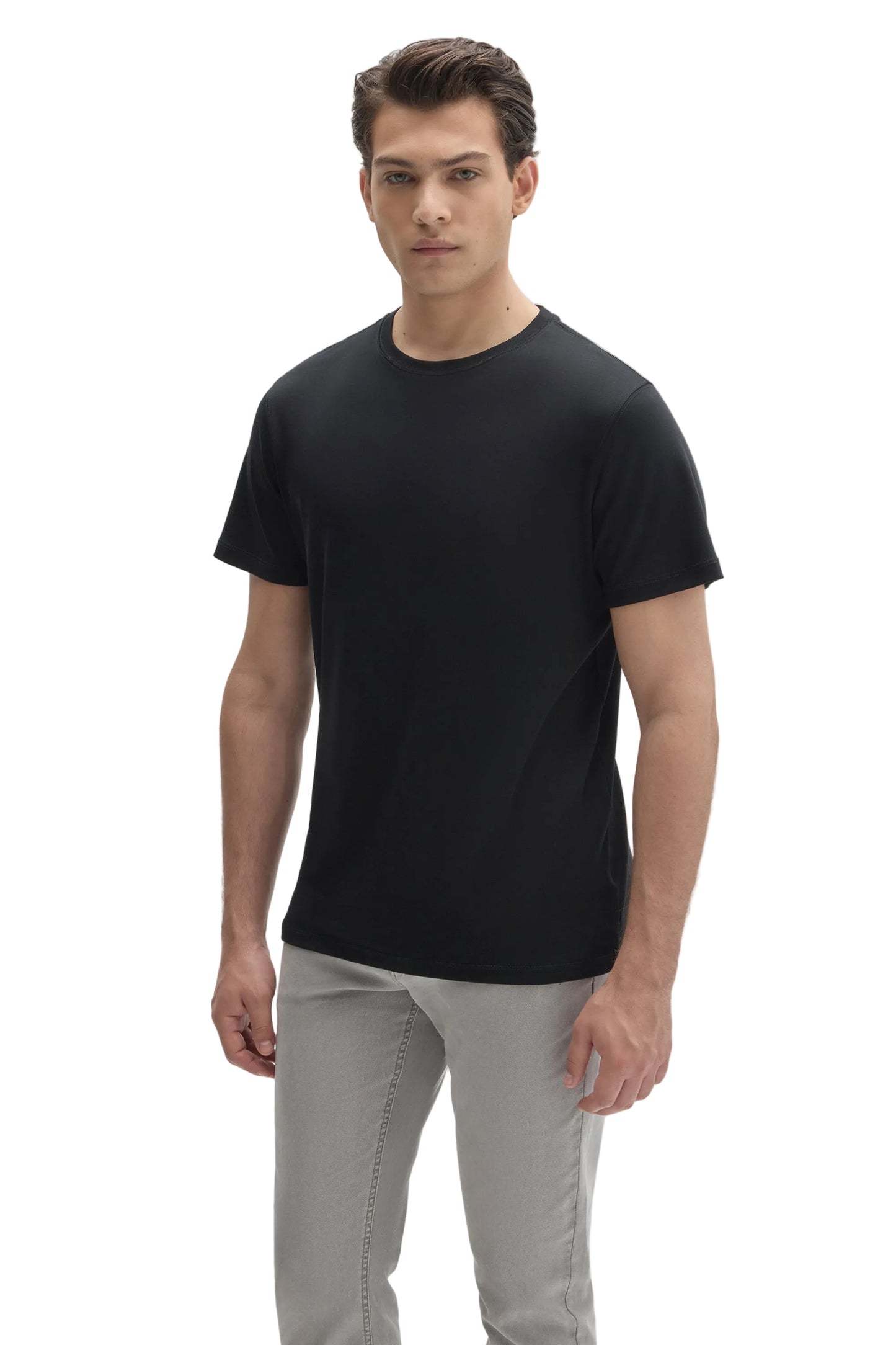 Man wearing a plain black crew neck short sleeve t-shirt with light gray pants