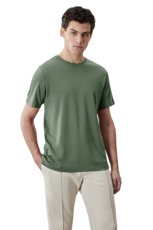 Man wearing sage green crew neck short sleeve t-shirt with beige trousers