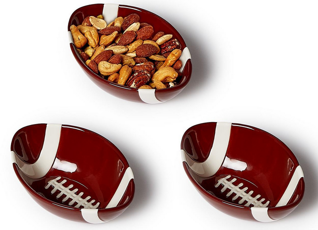 Football-shaped dark red ceramic tidbit bowls with white lace detailing, one filled with mixed nuts