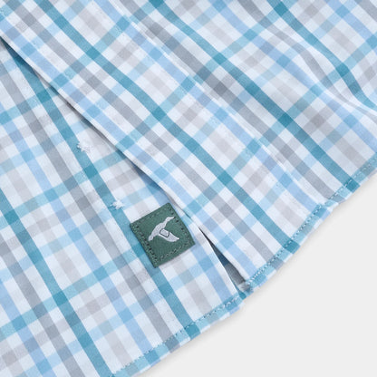 Blue and white plaid button-down shirt hem with small green woven brand label
