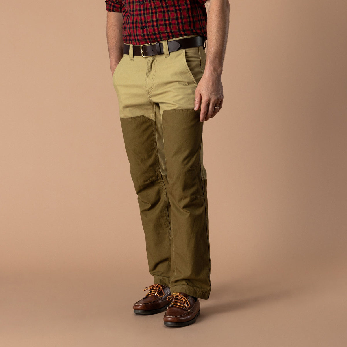 Two-tone tan and olive canvas briar pants with reinforced overlay panels and brown boots