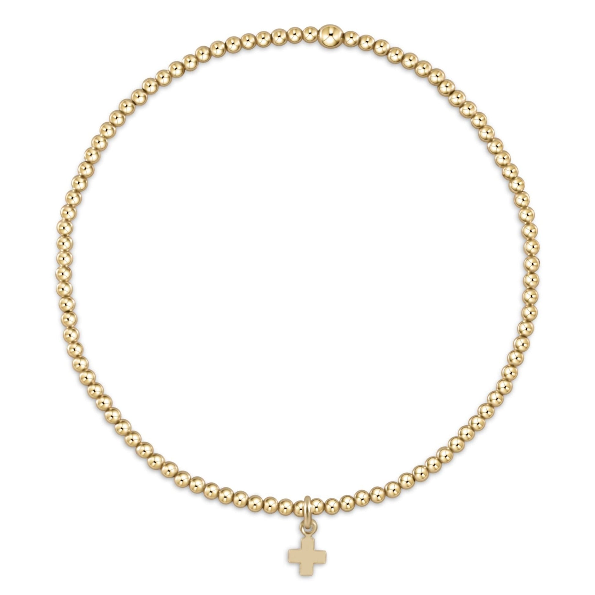 Gold beaded stretch bracelet with small gold cross charm pendant