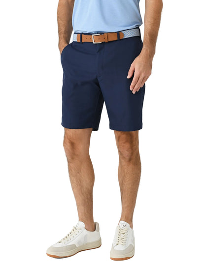 Men's navy blue performance chino shorts with brown belt and white sneakers
