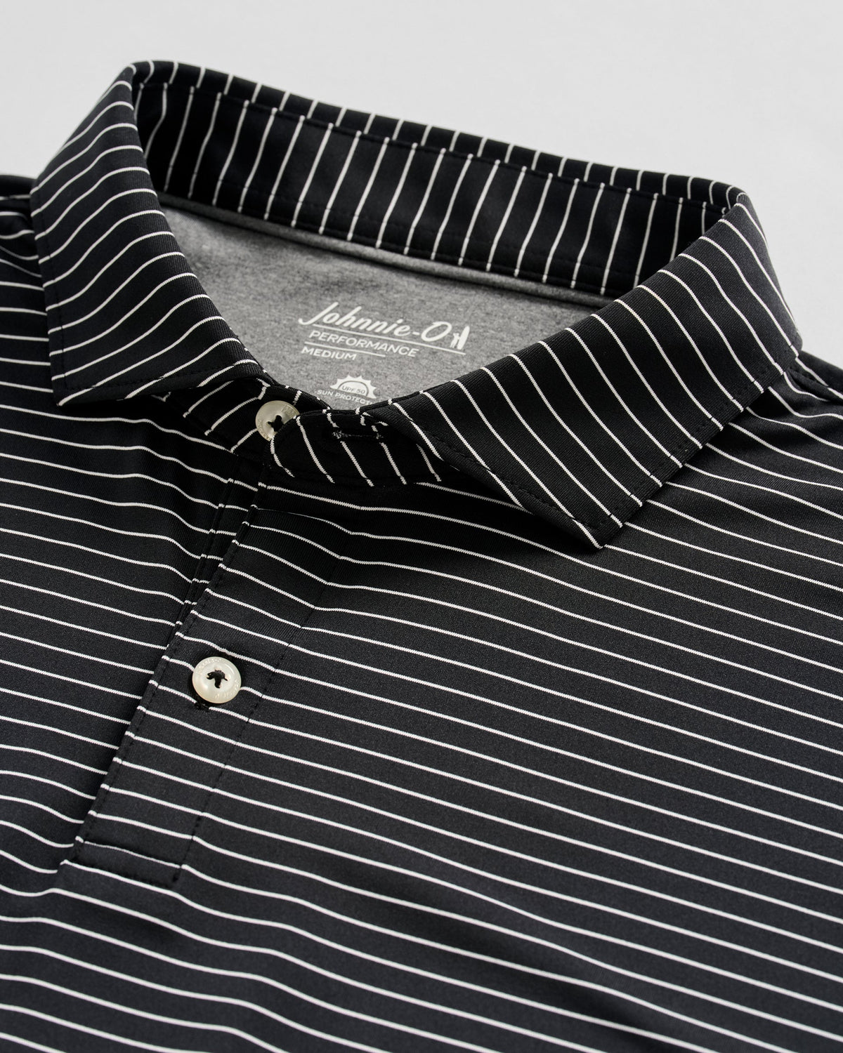 Johnnie-O black performance polo shirt with white pinstripes and button collar