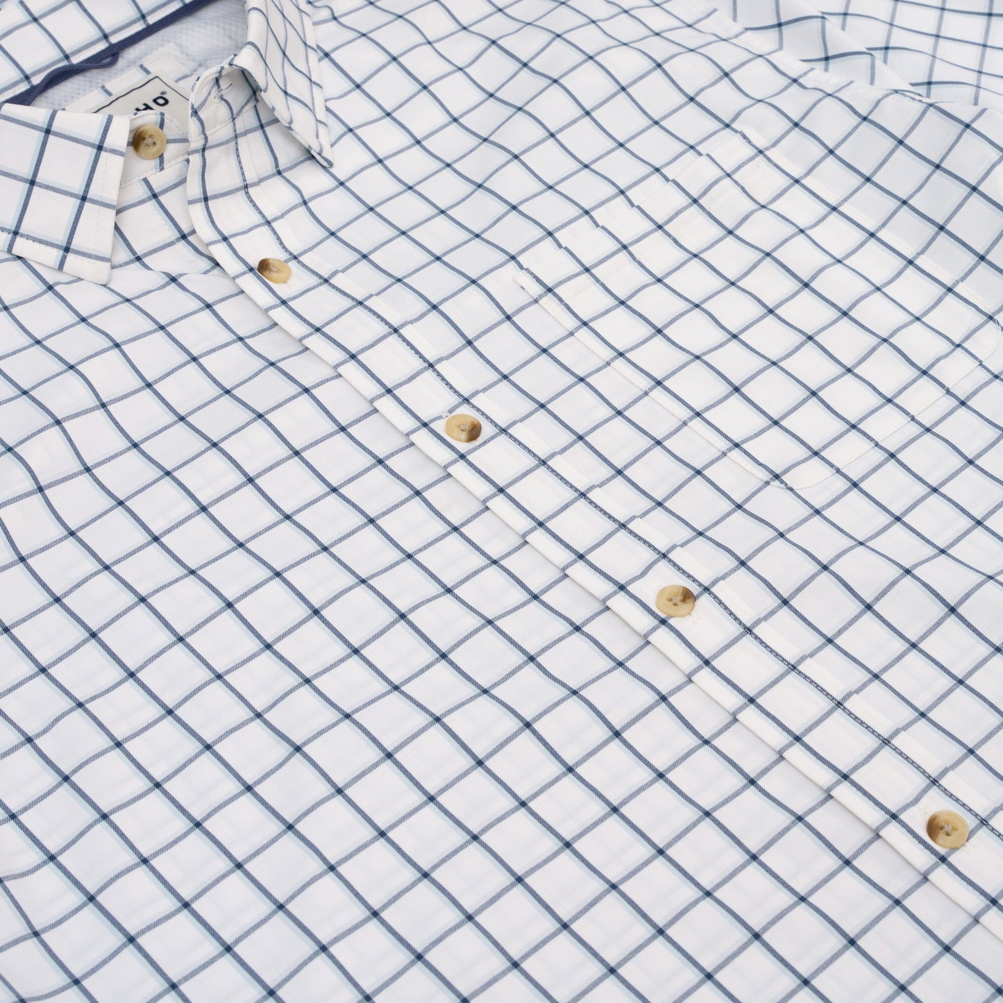 White and blue plaid button-down long sleeve shirt with tan buttons
